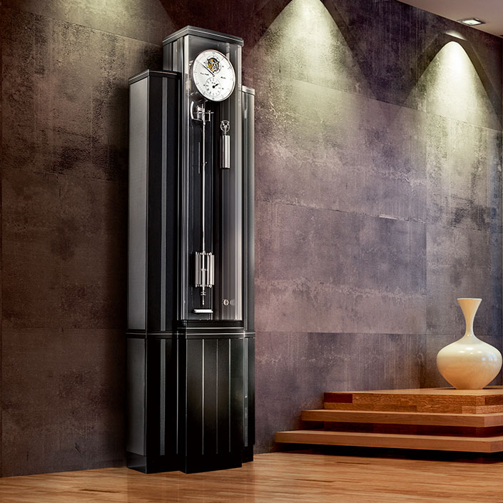 Standuhr Troja 20 von Erwin Sattler in modernem Design mit Glasfront in einem stilvoll beleuchteten Raum.