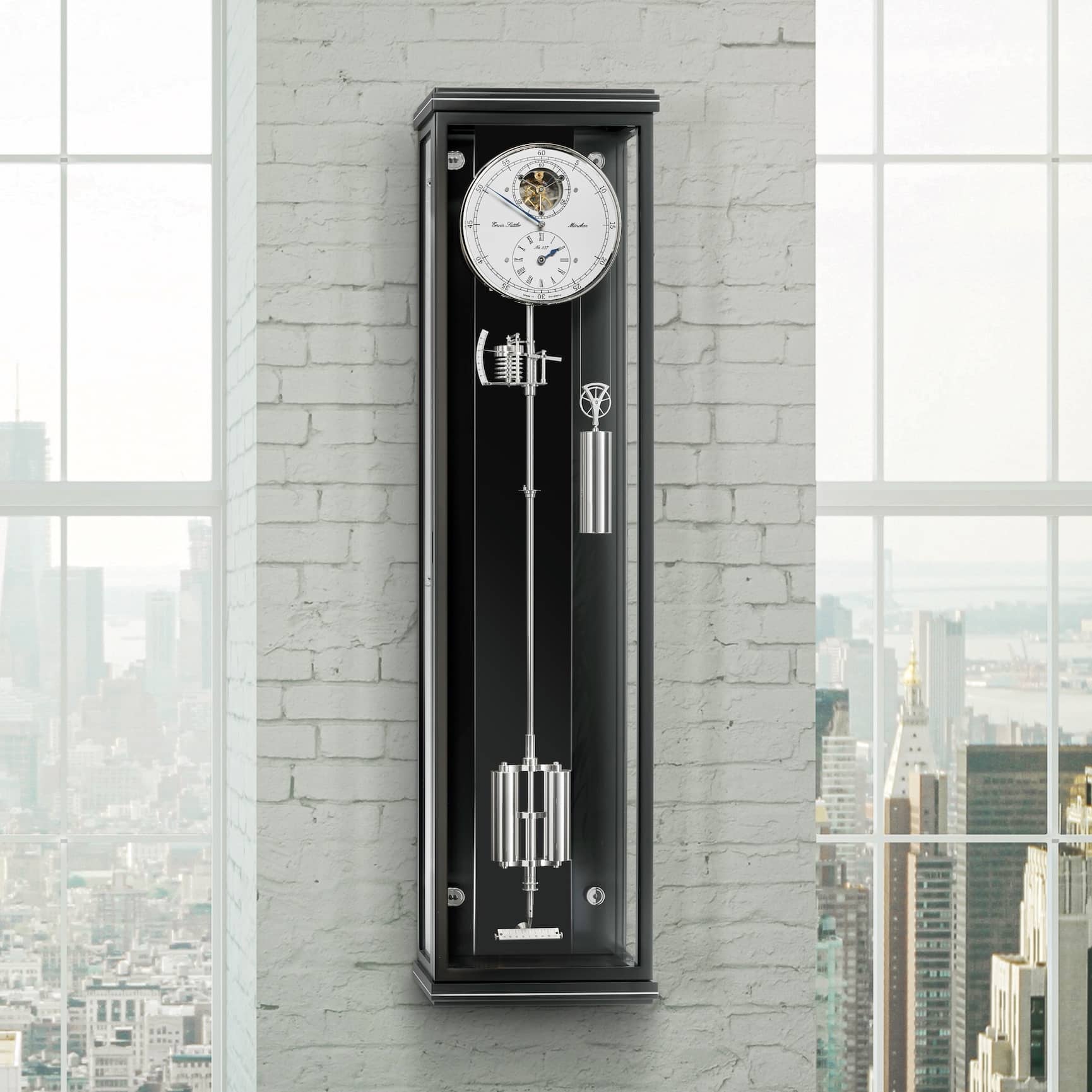 Wanduhr Classica Secunda 1995M mit sichtbarem Uhrwerk und Gewichten, montiert an einer weißen Ziegelwand, im Hintergrund Stadtansicht durch Fenster.