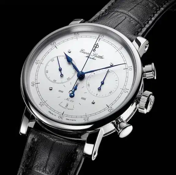 Edelstahl Armbanduhr Chronograph IIS von Erwin Sattler mit weißem Zifferblatt, blauen Zeigern und schwarzem Lederarmband, mit mehreren Zifferblättern und Drückern an der Seite.