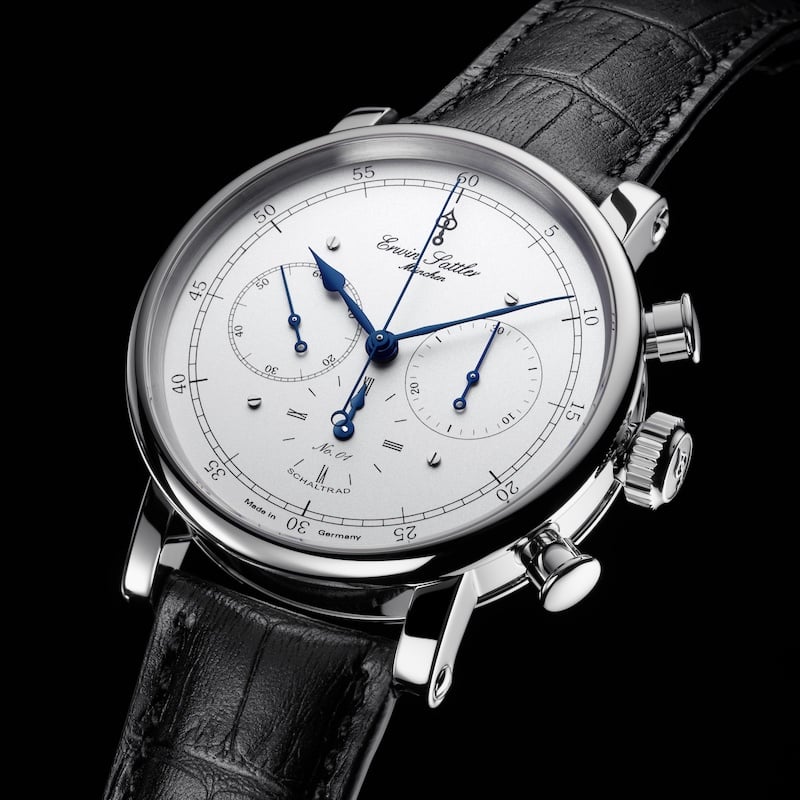 Edelstahl Armbanduhr Chronograph IIS von Erwin Sattler mit weißem Zifferblatt, blauen Zeigern und schwarzem Lederarmband, mit mehreren Zifferblättern und Drückern an der Seite.