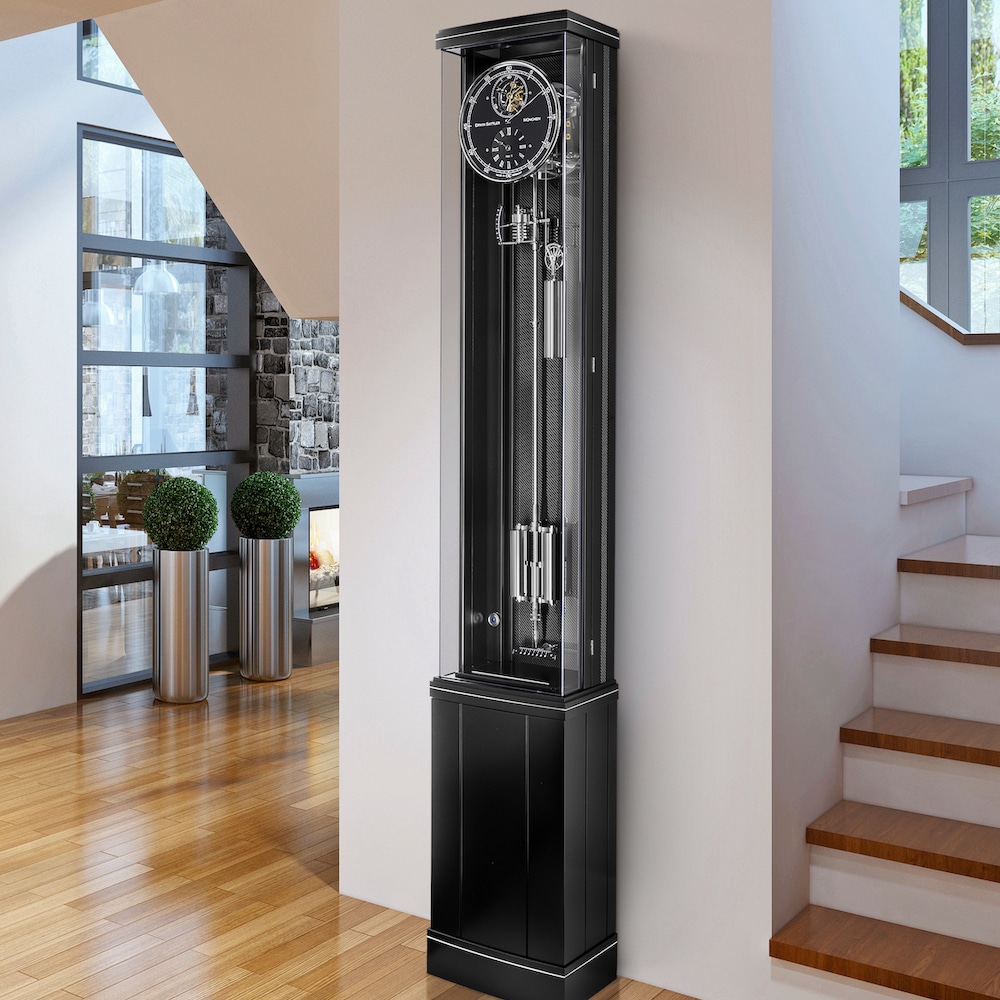 Standuhr Illumina Secunda von Erwin Sattler in einem modernen Wohnbereich mit Holzboden, neben einer offenen Treppe und einer Wand mit großen Fenstern.