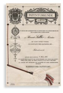 Historische deutsche Patenturkunde mit kaiserlichem Wappen und Verzierungen, beige mit rotem Siegel und Kordel.