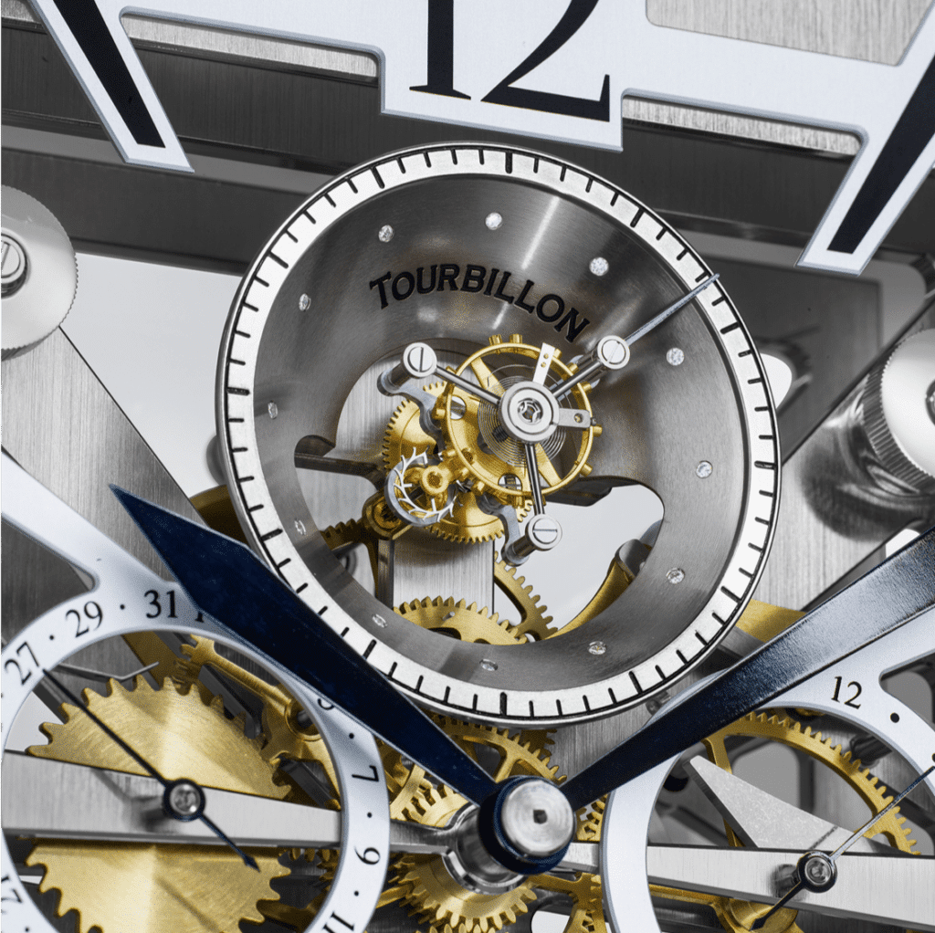 Detailaufnahme eines Uhrwerks mit sichtbarem Tourbillon in einem silbernen Gehäuse, umgeben von goldenen Zahnrädern und blauen Zeigern.