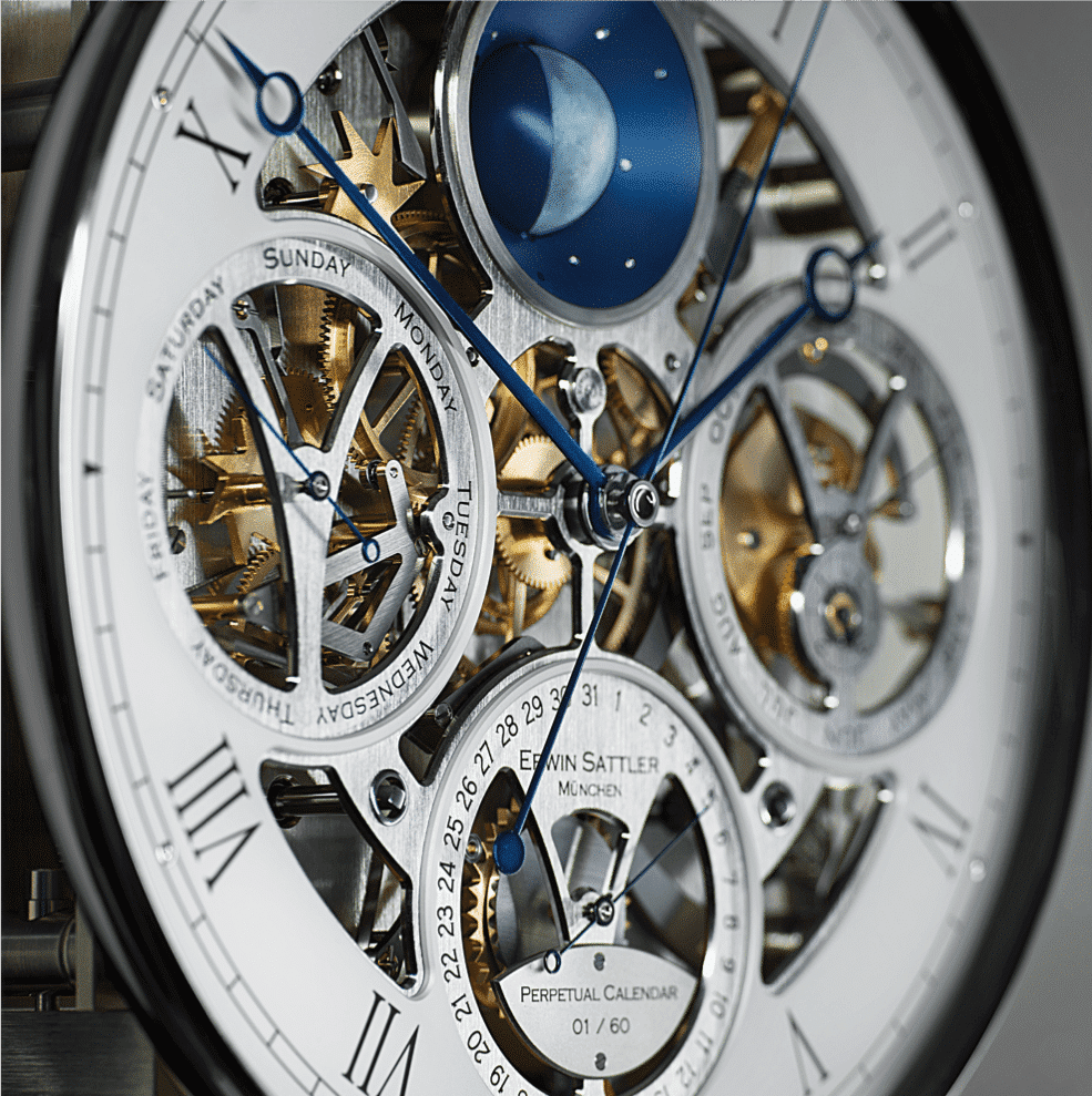 Detailaufnahme des komplizierten Uhrwerks der Opus Perpetual von Erwin Sattler mit sichtbaren Zahnrädern, blauen Zeigern und Mondphasenanzeige. Die Tage der Woche sind auf kreisförmigen Anzeigen sichtbar. Das Uhrwerk zeichnet sich durch seinen ewigen Kalender aus