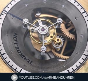 Nahaufnahme eines Tourbillon-Uhrwerks von Erwin Sattler, das die komplizierten Zahnräder und Mechanismen in einem trichterförmigen Gehäuse zeigt.