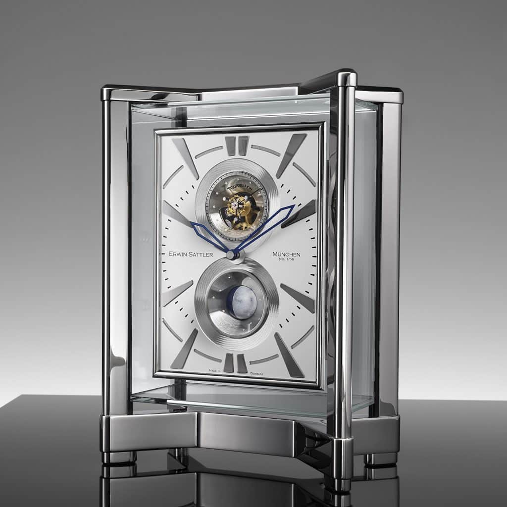 Tischuhr Opus Moon Tourbillon von Erwin Sattler mit sichtbarem Uhrwerk, blauen Stunden- und Minutenzeigern und einer Kugelmondphasen Anzeige. Moderner, transparenter Gehäusedeckel und -rahmen auf glänzendem Sockel.
