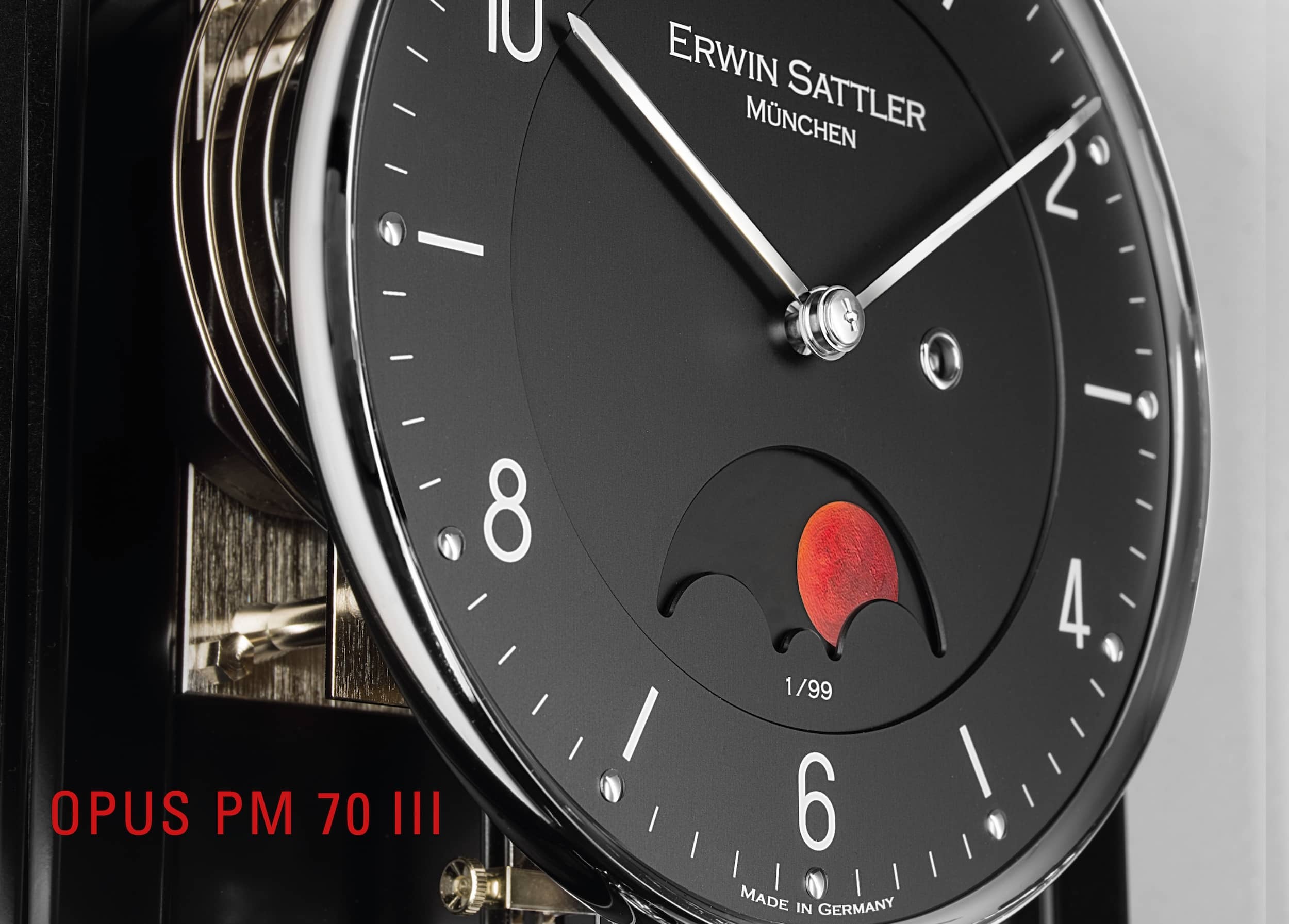 Nahaufnahme des Zifferblattes der Opus PM70III von Erwin Sattler mit schwarzem Zifferblatt, silbernen Zeigern und zusätzlichen Funktionselementen, darunter eine Blutmondphasenanzeige und Seriennummer.